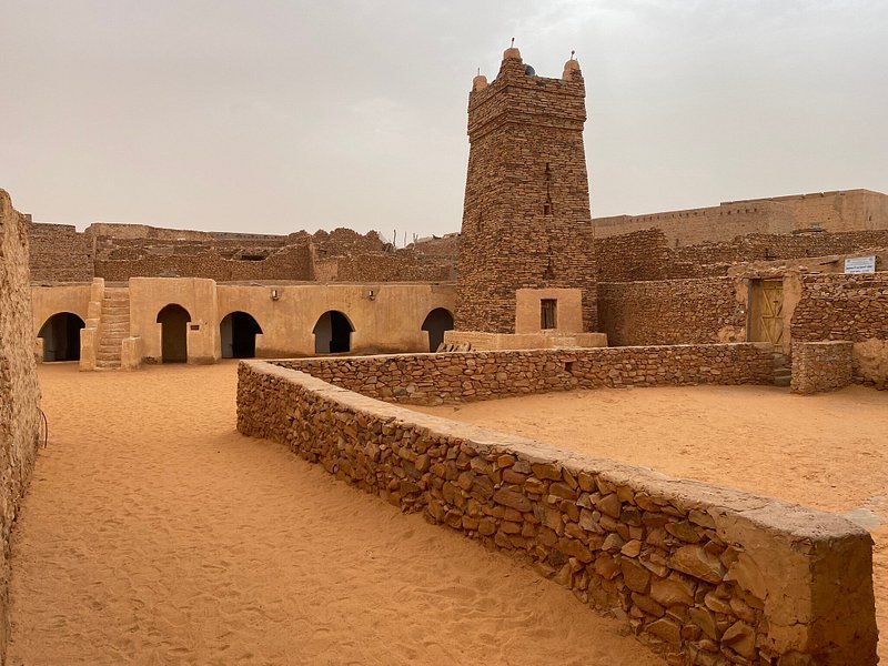 Historic Chinguetti Mosque, Mauritania, featuring ancient stone architecture. A highlight of Adrar Desert Adventure Tours.